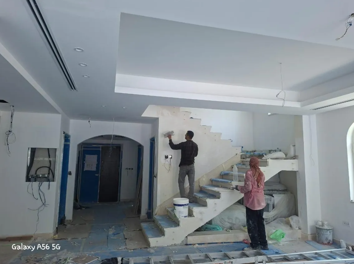 Tile mason laying floor tiles during a renovation